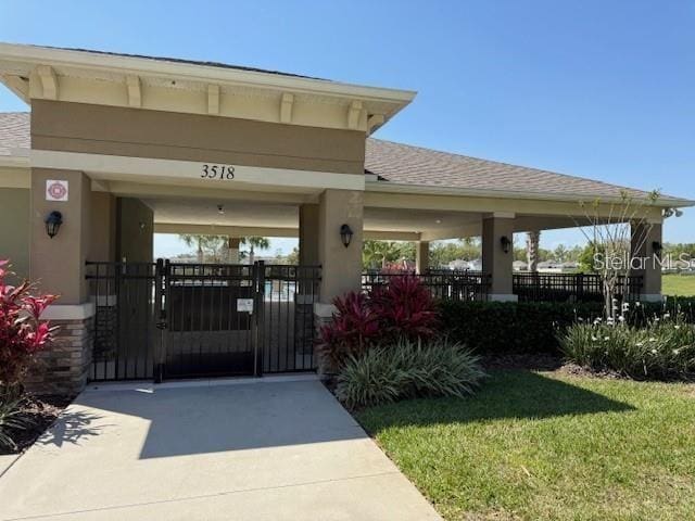 6780 Coral Berry Dr, Mount Dora, FL 32757 - property entrance featuring a gate, stucco siding, and roof with shingles