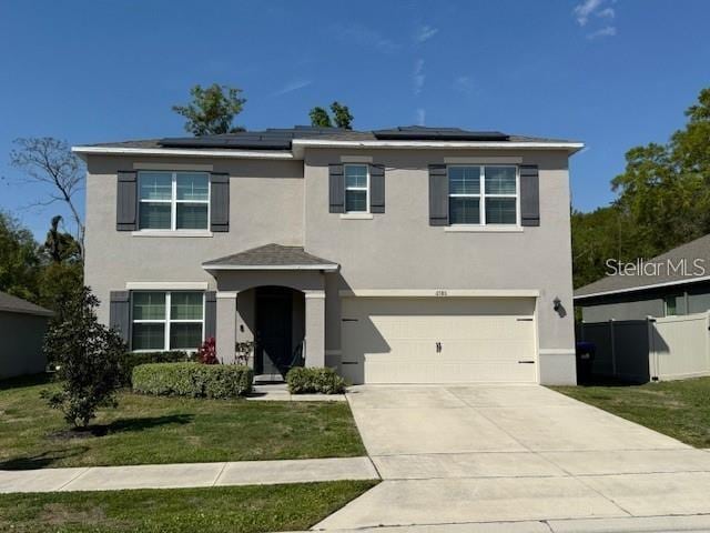 6780 Coral Berry Dr, Mount Dora, FL 32757 - traditional-style home with a garage, stucco siding, concrete driveway, and roof mounted solar panels