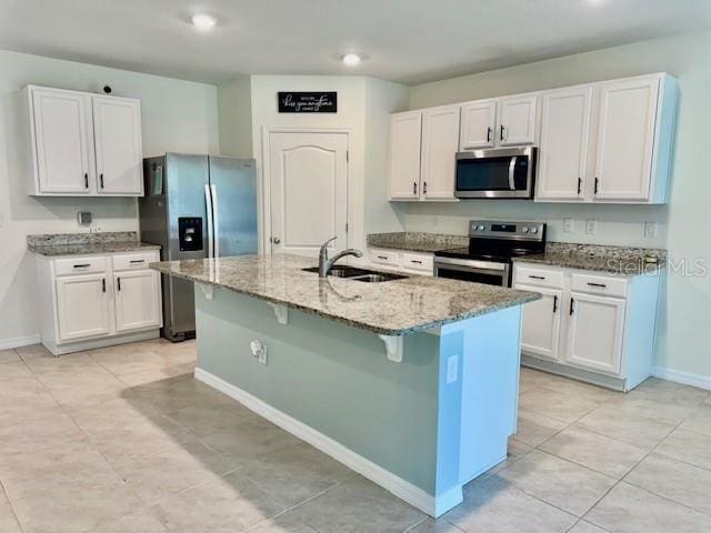 6780 Coral Berry Dr, Mount Dora, FL 32757 - kitchen with appliances with stainless steel finishes, a sink, light stone counters, baseboards, and white cabinetry