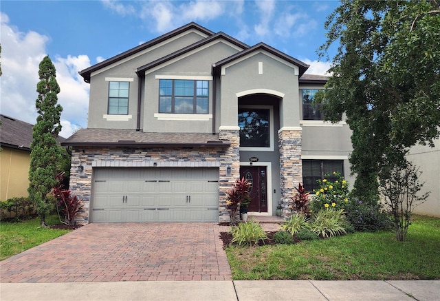 5107 Appenine Loop W, Saint Cloud, FL 34771 - view of front of home featuring stucco siding, stone siding, a garage, and decorative driveway