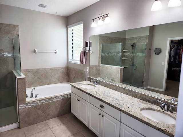 5107 Appenine Loop W, Saint Cloud, FL 34771 - bathroom featuring a stall shower, double vanity, a bath, tile patterned flooring, and a walk in closet