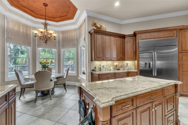 9729 Lake Hugh Dr, Gotha, FL 34734 - kitchen with built in refrigerator, a chandelier, light stone counters, hanging light fixtures, and backsplash