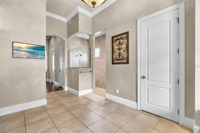 9729 Lake Hugh Dr, Gotha, FL 34734 - foyer entrance with crown molding, arched walkways, light tile patterned floors, and baseboards