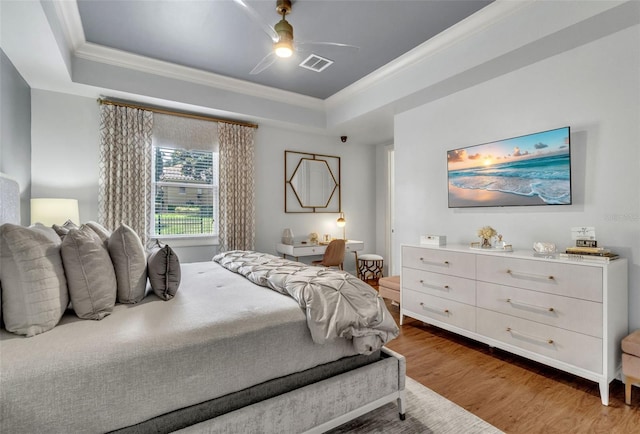 9729 Lake Hugh Dr, Gotha, FL 34734 - bedroom featuring a tray ceiling, wood finished floors, ornamental molding, and a ceiling fan