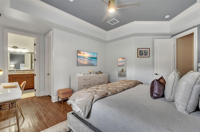 9729 Lake Hugh Dr, Gotha, FL 34734 - bedroom with a tray ceiling, wood finished floors, ensuite bath, ornamental molding, and ceiling fan