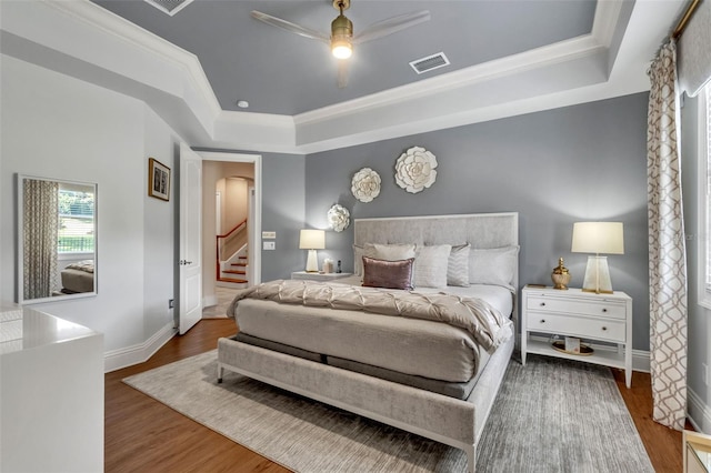 9729 Lake Hugh Dr, Gotha, FL 34734 - bedroom featuring a raised ceiling, baseboards, wood finished floors, ornamental molding, and arched walkways