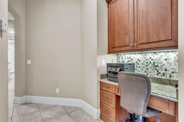 9729 Lake Hugh Dr, Gotha, FL 34734 - office area featuring built in study area, light tile patterned flooring, baseboards, and arched walkways