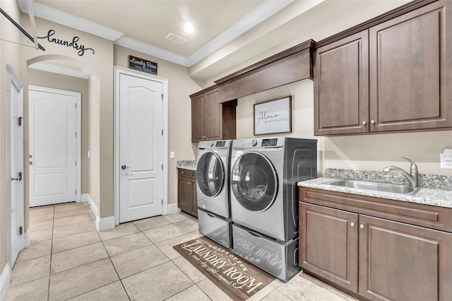 9729 Lake Hugh Dr, Gotha, FL 34734 - laundry area featuring cabinet space, independent washer and dryer, ornamental molding, light tile patterned floors, and arched walkways