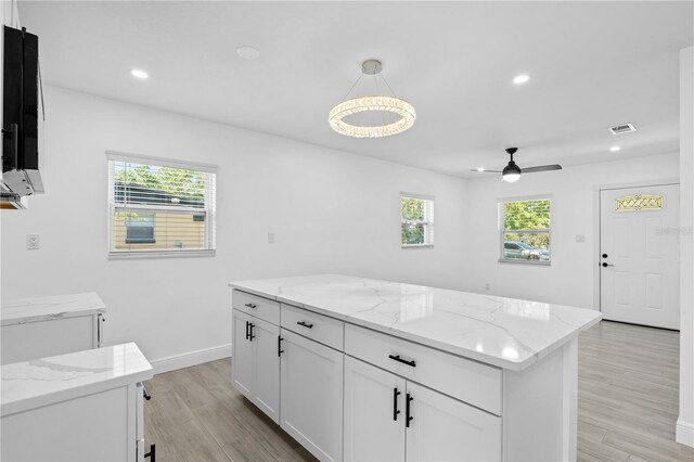7701 Cassino Ave, Orlando, FL 32819 - kitchen with healthy amount of natural light, light wood-style flooring, a ceiling fan, white cabinets, and recessed lighting