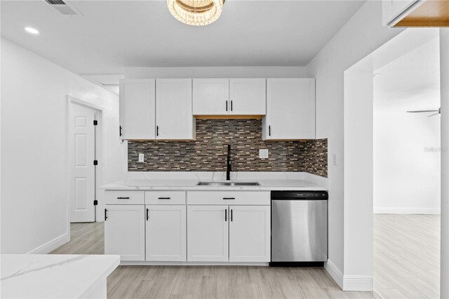 7701 Cassino Ave, Orlando, FL 32819 - kitchen featuring stainless steel dishwasher, a sink, light wood finished floors, white cabinets, and baseboards
