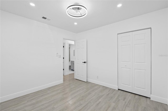7701 Cassino Ave, Orlando, FL 32819 - unfurnished bedroom featuring light wood finished floors, baseboards, recessed lighting, and a closet