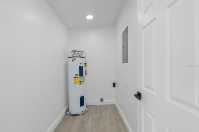 7701 Cassino Ave, Orlando, FL 32819 - laundry room featuring water heater, hookup for an electric dryer, light wood finished floors, electric panel, and baseboards