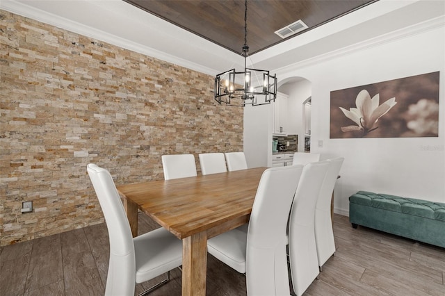 5365 Bowman Dr, Winter Garden, FL 34787 - dining space with a chandelier, a raised ceiling, arched walkways, and wood finished floors
