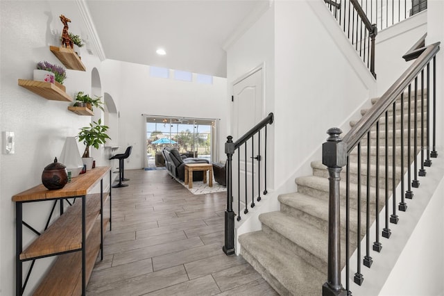 5365 Bowman Dr, Winter Garden, FL 34787 - entryway with crown molding, stairs, wood finished floors, a high ceiling, and arched walkways