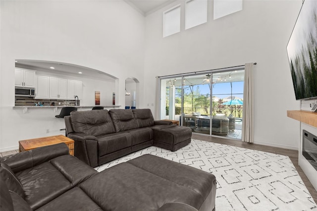 5365 Bowman Dr, Winter Garden, FL 34787 - living room with arched walkways, a high ceiling, light wood finished floors, and baseboards
