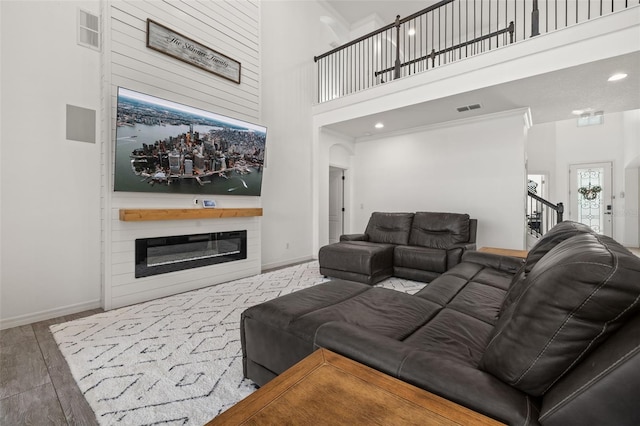 5365 Bowman Dr, Winter Garden, FL 34787 - living room featuring a glass covered fireplace, a high ceiling, baseboards, and wood finished floors