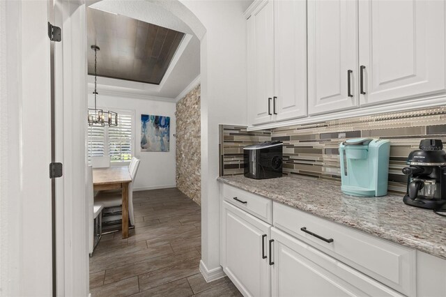 5365 Bowman Dr, Winter Garden, FL 34787 - kitchen featuring baseboards, dark wood-style floors, white cabinets, backsplash, and a raised ceiling