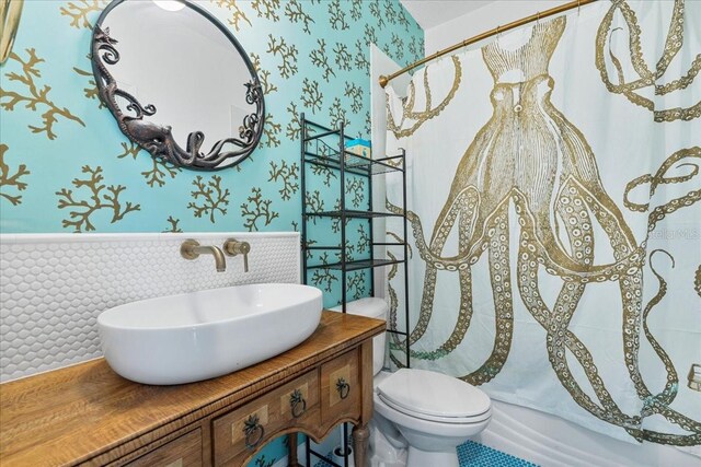 1550 Bluewater Run, Chuluota, FL 32766 - bathroom with wallpapered walls, a wainscoted wall, vanity, and shower / tub combo with curtain