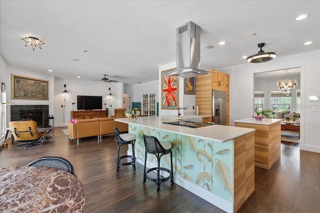 1550 Bluewater Run, Chuluota, FL 32766 - kitchen with island range hood, a center island, a textured ceiling, light countertops, and a fireplace