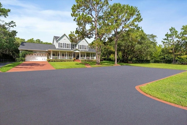 1550 Bluewater Run, Chuluota, FL 32766 - view of front of property with a porch, asphalt driveway, a front lawn, and a garage