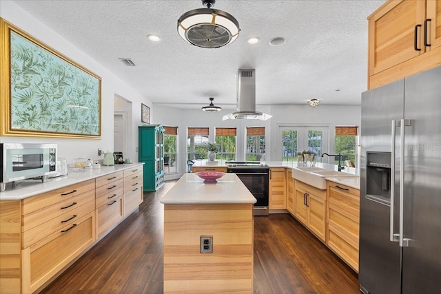 1550 Bluewater Run, Chuluota, FL 32766 - kitchen with appliances with stainless steel finishes, island range hood, a textured ceiling, light brown cabinetry, and light countertops