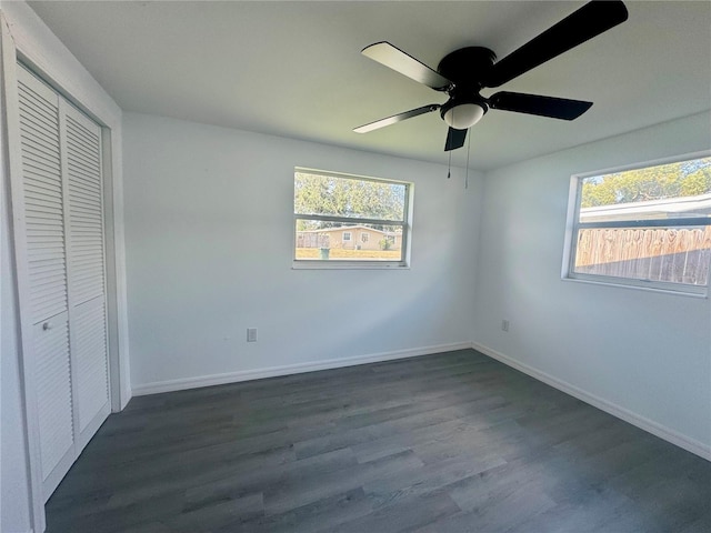 804 Starke Lake Cir, Ocoee, FL 34761 - unfurnished bedroom with multiple windows, dark wood-style floors, baseboards, and a closet