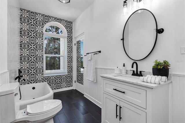 802 S 10th St, Haines City, FL 33844 - bathroom featuring toilet, wainscoting, a bath, and vanity