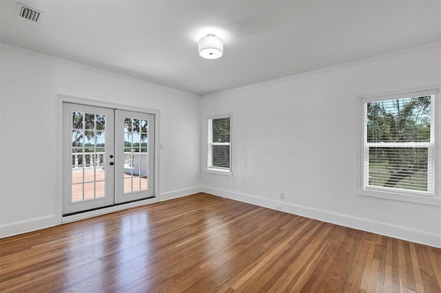 802 S 10th St, Haines City, FL 33844 - empty room with plenty of natural light, hardwood / wood-style floors, french doors, and crown molding