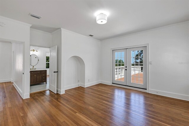 802 S 10th St, Haines City, FL 33844 - empty room with wood-type flooring, french doors, a sink, baseboards, and ornamental molding