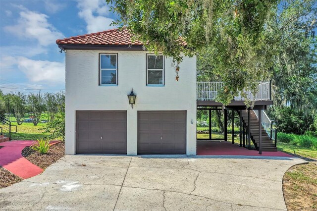 802 S 10th St, Haines City, FL 33844 - view of front of home with a garage, stucco siding, stairs, and a tile roof