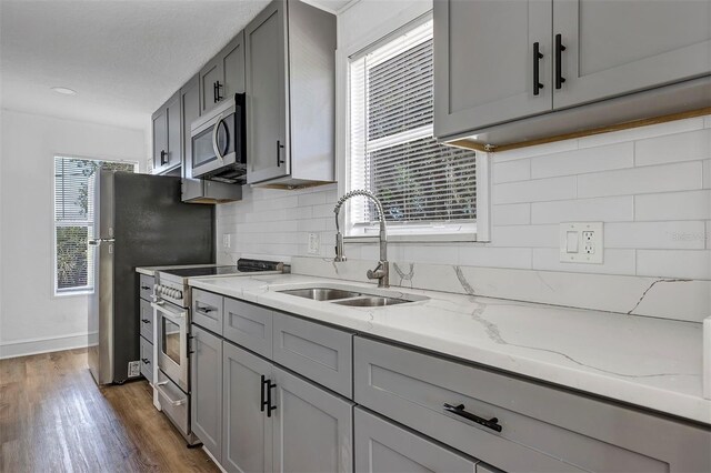802 S 10th St, Haines City, FL 33844 - kitchen with stainless steel appliances, a sink, gray cabinetry, and decorative backsplash