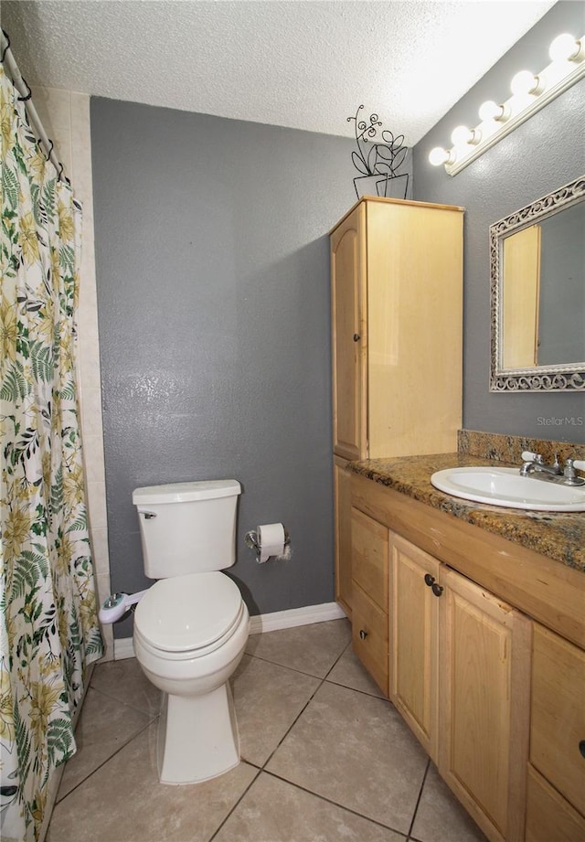 610 Heatherton Vlg Unit 610, Altamonte Springs, FL 32714 - bathroom featuring vanity, toilet, a textured ceiling, tile patterned floors, and baseboards