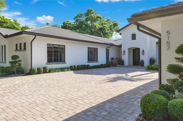 5157 Latrobe Dr, Windermere, FL 34786 - view of front of house featuring a tiled roof, stucco siding, and decorative driveway