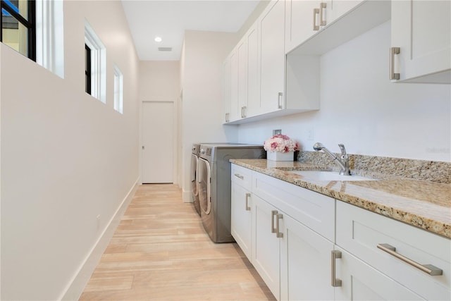 5157 Latrobe Dr, Windermere, FL 34786 - laundry room with washer and clothes dryer, light wood-style floors, cabinet space, baseboards, and recessed lighting