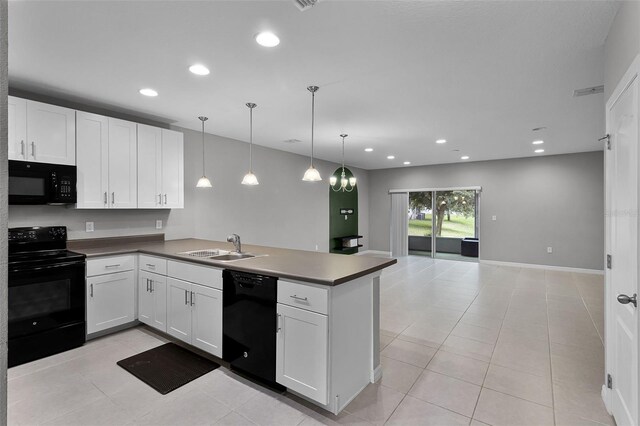 228 Primrose Dr, Davenport, FL 33837 - kitchen with black appliances, a peninsula, white cabinets, a sink, and light tile patterned floors