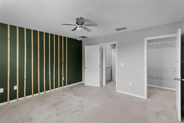 228 Primrose Dr, Davenport, FL 33837 - unfurnished bedroom with baseboards, washer / clothes dryer, a walk in closet, carpet floors, and wallpapered walls