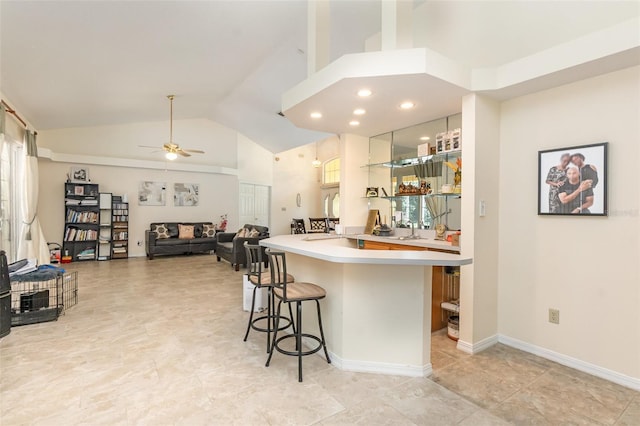 1910 Palm View Dr, Apopka, FL 32712 - kitchen featuring a breakfast bar area, ceiling fan, light countertops, and high vaulted ceiling