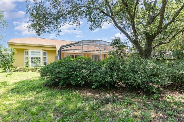 1910 Palm View Dr, Apopka, FL 32712 - rear view of property featuring a yard, stucco siding, and a lanai