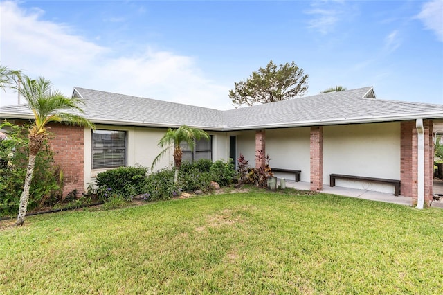 109 Coral Reef Ct N, Palm Coast, FL 32137 - view of front of house featuring a front lawn, a shingled roof, and brick siding