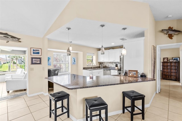 109 Coral Reef Ct N, Palm Coast, FL 32137 - kitchen featuring dishwasher, a sink, a peninsula, white cabinets, and light tile patterned floors