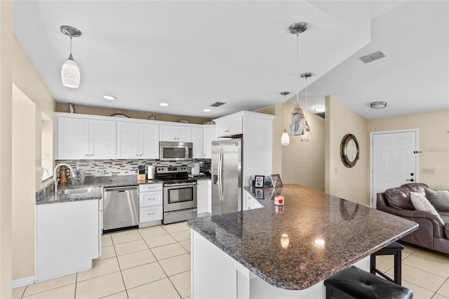 109 Coral Reef Ct N, Palm Coast, FL 32137 - kitchen featuring appliances with stainless steel finishes, a peninsula, a sink, light tile patterned floors, and open floor plan