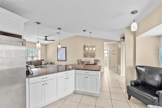 109 Coral Reef Ct N, Palm Coast, FL 32137 - kitchen featuring freestanding refrigerator, light tile patterned floors, dark stone countertops, white cabinets, and a ceiling fan