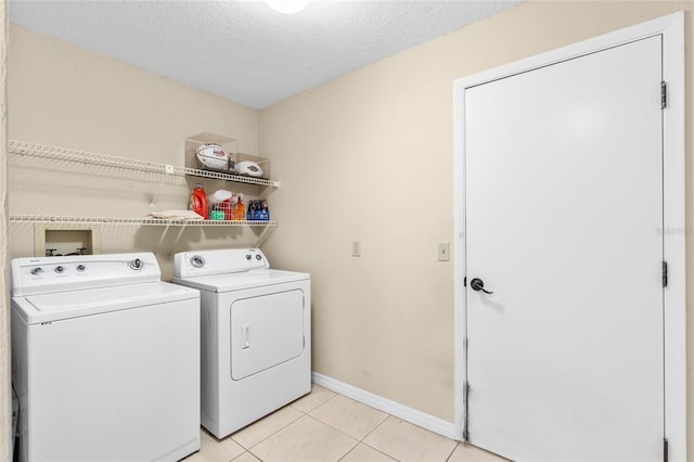 109 Coral Reef Ct N, Palm Coast, FL 32137 - laundry area featuring washer and clothes dryer, light tile patterned floors, baseboards, and a textured ceiling