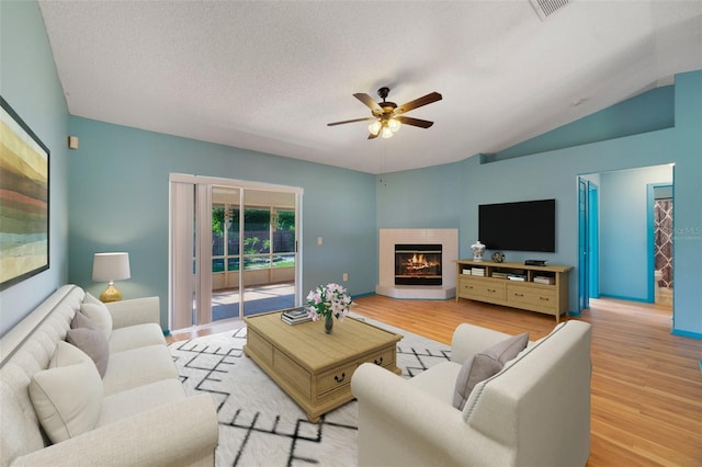 925 S Dean Cir, Deltona, FL 32738 - living area featuring ceiling fan, wood finished floors, a glass covered fireplace, lofted ceiling, and a textured ceiling