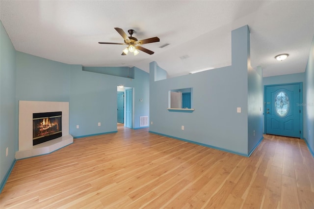 925 S Dean Cir, Deltona, FL 32738 - unfurnished living room with a ceiling fan, light wood-type flooring, vaulted ceiling, a fireplace, and baseboards