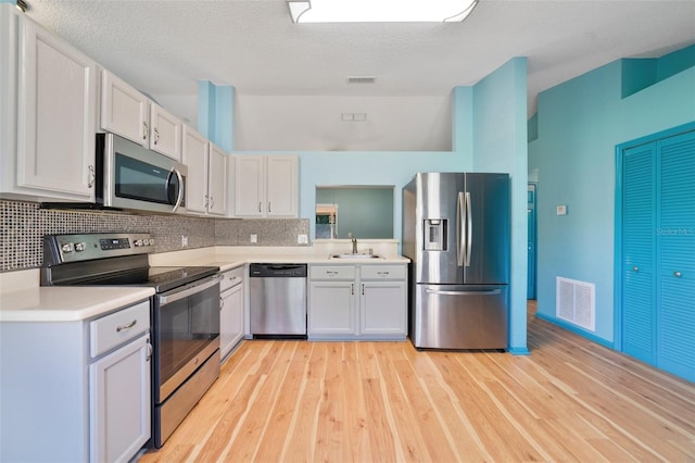 925 S Dean Cir, Deltona, FL 32738 - kitchen with appliances with stainless steel finishes, a sink, light wood-style flooring, light countertops, and decorative backsplash