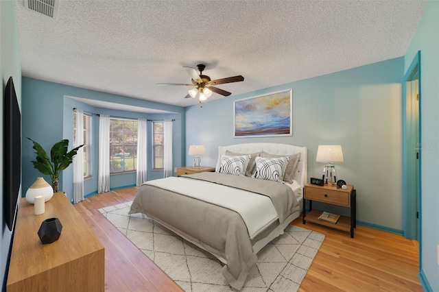 925 S Dean Cir, Deltona, FL 32738 - bedroom featuring a textured ceiling, light wood finished floors, a ceiling fan, and baseboards