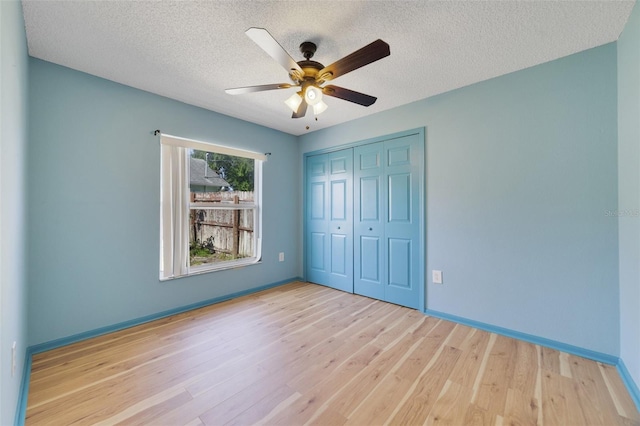 925 S Dean Cir, Deltona, FL 32738 - unfurnished bedroom with wood finished floors, a closet, a textured ceiling, baseboards, and ceiling fan