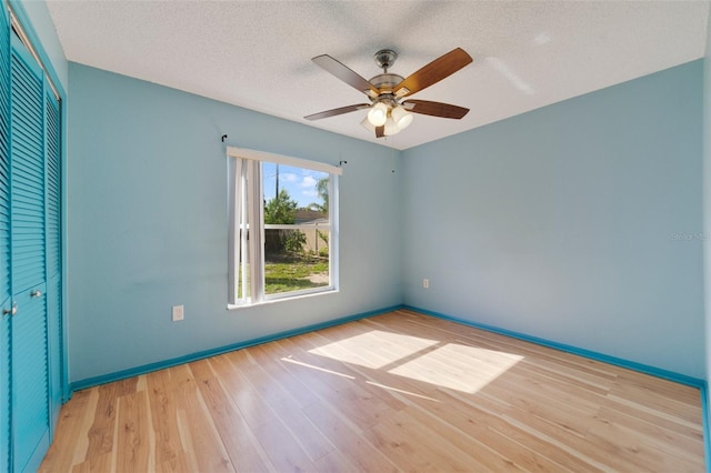 925 S Dean Cir, Deltona, FL 32738 - unfurnished bedroom with light wood-type flooring, baseboards, a textured ceiling, a closet, and a ceiling fan