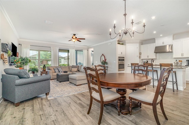 2342 Clemblue Rd, Clermont, FL 34715 - dining area featuring crown molding, light wood-type flooring, a ceiling fan, a chandelier, and recessed lighting
